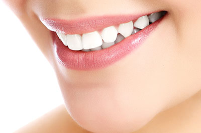 The image shows a close-up of a person s smiling face with their teeth, focusing on the lips and teeth area, likely for cosmetic dental product promotion.