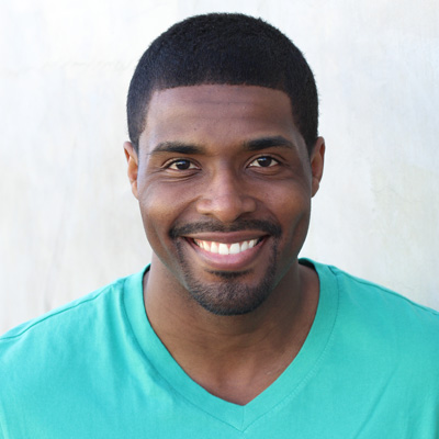 An elderly couple sharing a joyful moment together outdoors, with the man wearing glasses and both smiling broadly at the camera.