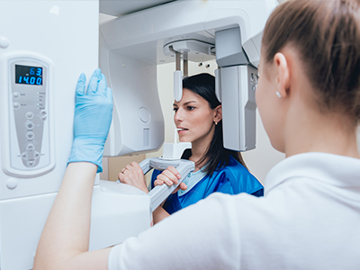 In the image, there are two individuals, one woman wearing a white lab coat and a stethoscope around her neck who appears to be examining another person with a scanner.